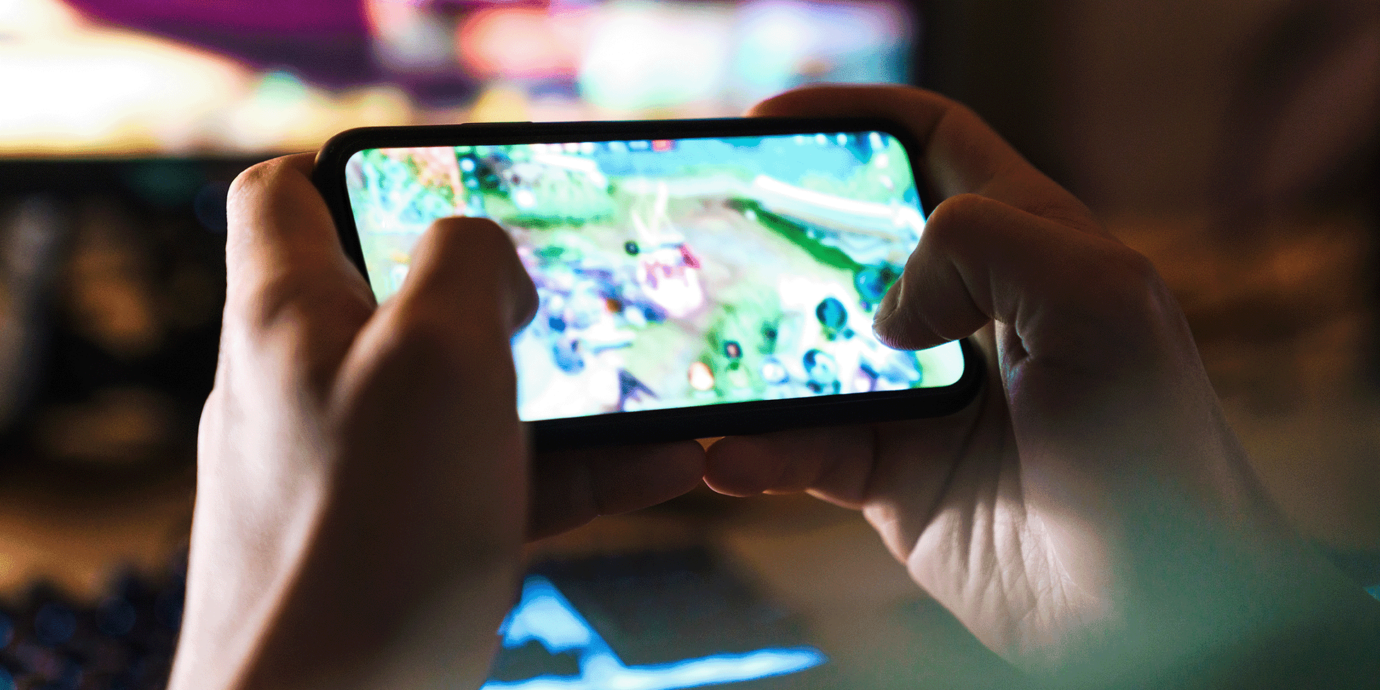 two hands holding a phone with game on